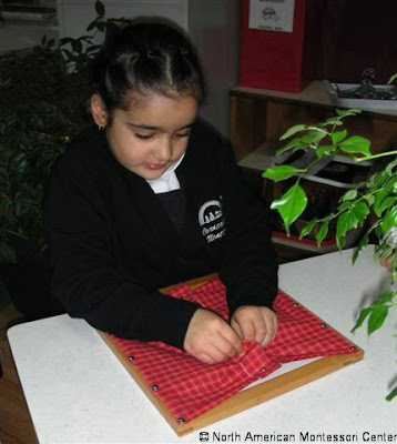 NAMC Montessori Classroom Practical Life Activities girl working with Montessori Dressing Frame 
