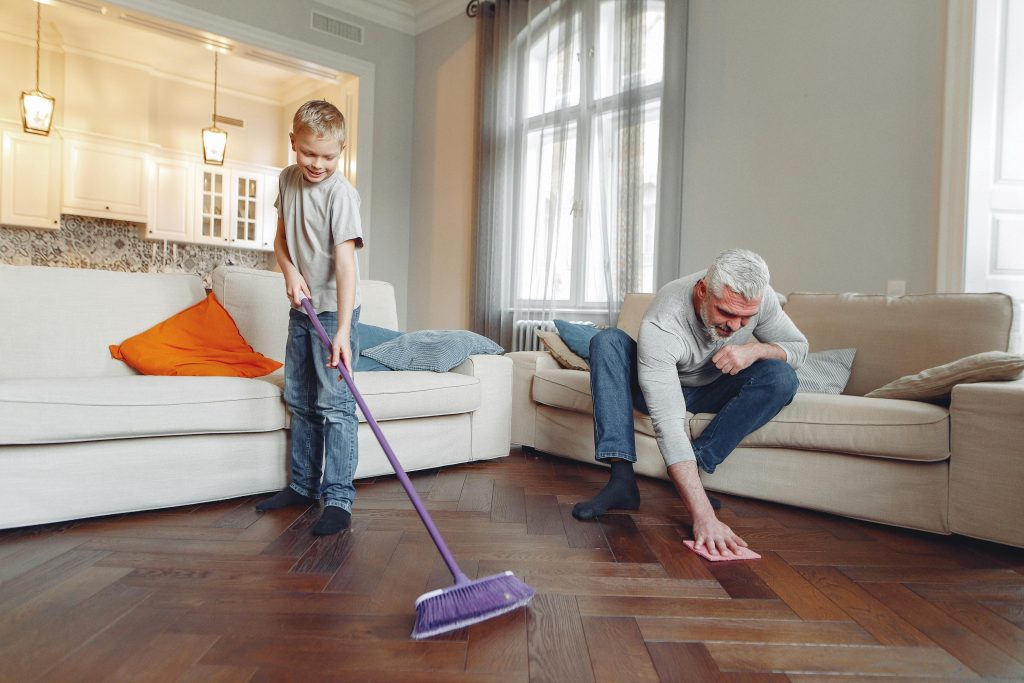 child and adult cleaning living room floor
