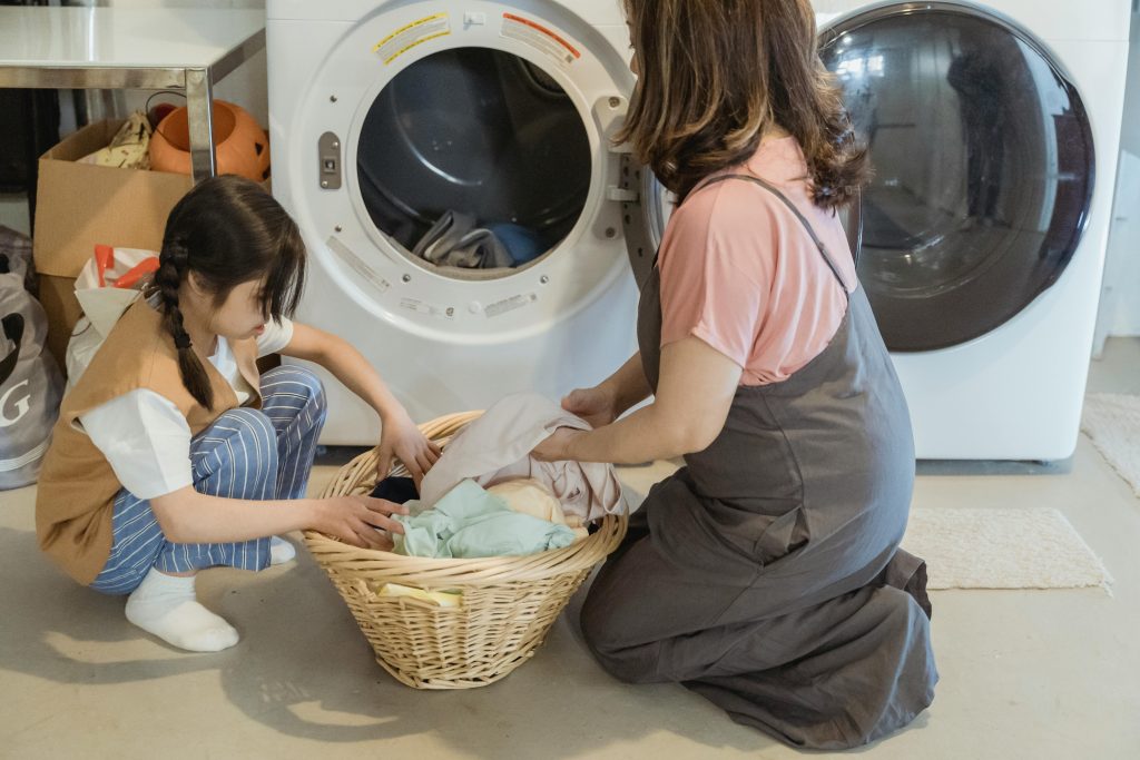 child and adult sorting laundry