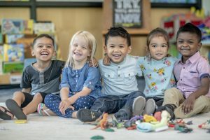 Group of Montessori toddlers sitting together and smiling