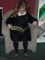 NAMC montessori education builds development reading girl in chair