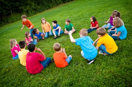 NAMC Montessori outdoor environment cosmic education peace. Children in a circle playing a game
