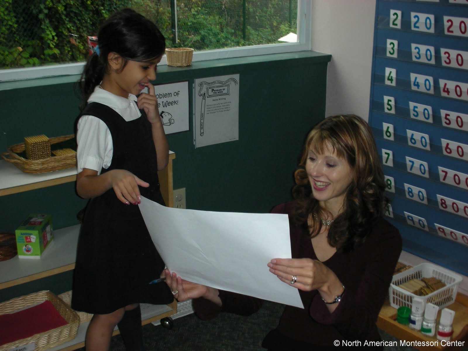 NAMC montessori teacher school year end preparation loking at girl's work