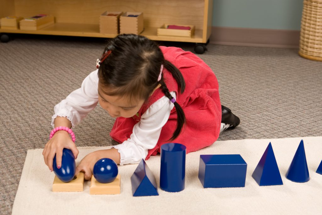 Montessori student working with the Geometric Solids