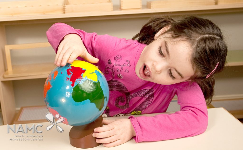 Montessori early childhood student examining a Colored Globe
