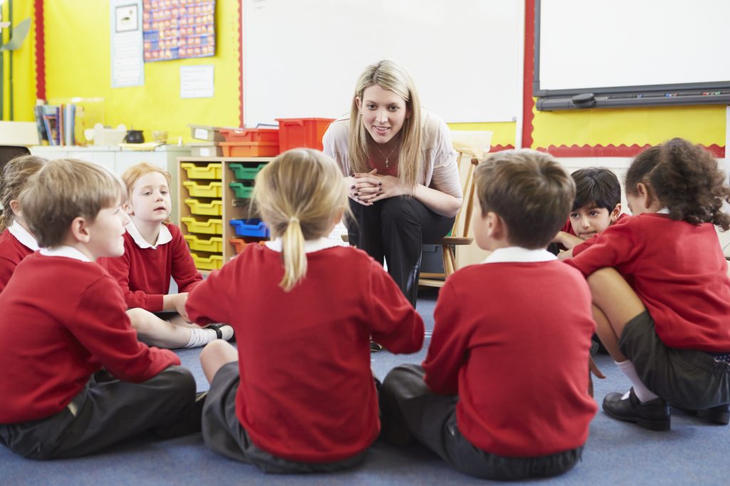 Montessori teacher presenting the Five Great Lessons to group of students