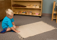 NAMC montessori preschool first day boy rolling out mat
