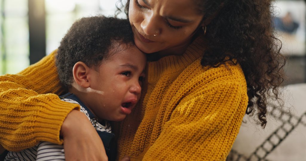 Sad toddler being comforted by parent