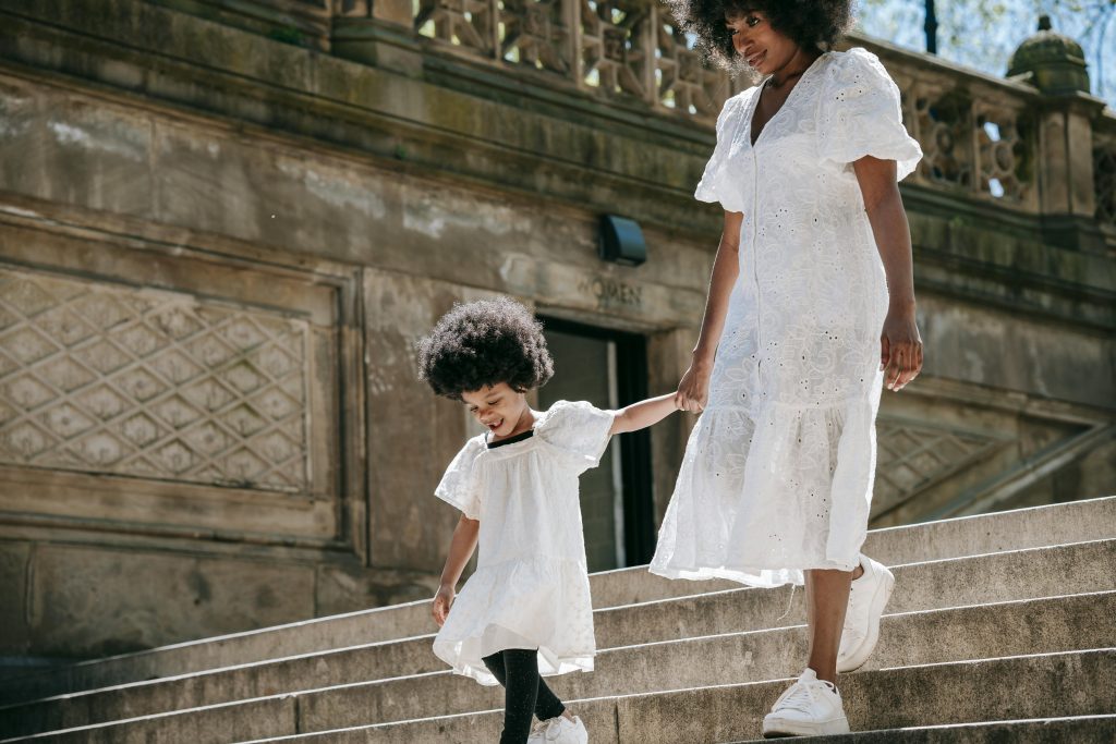 Mother and daughter walking down stone staircase outside