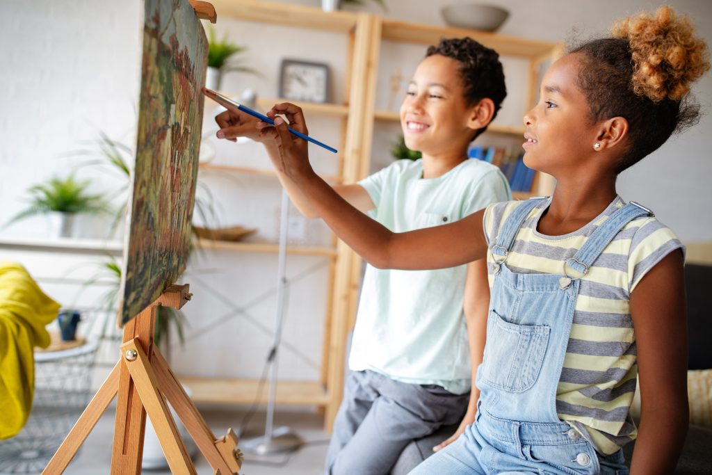 two children painting at easel