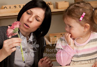 NAMC montessori views on infant toddler behavior child and montessori parent with flower