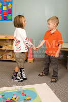 girl and boy shake hands NAMC montessori children grace courtesy practical life activity
