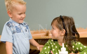 boy and girl smiling at each other fundamental thing learned from NAMC montessori mentor resolving student conflict