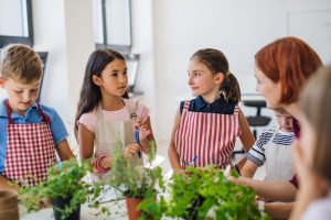 Montessori elementary students working at table with potted plants