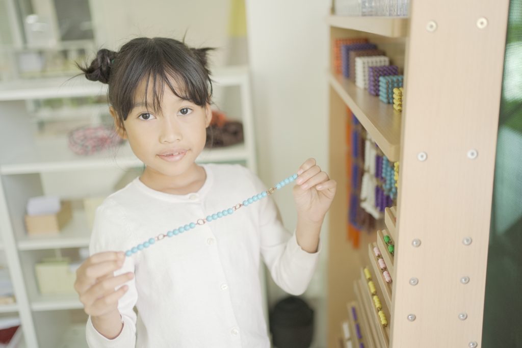Montessori student holding bead chain at Bead Cabinet