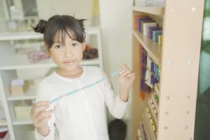 Montessori student holding bead chain at Bead Cabinet