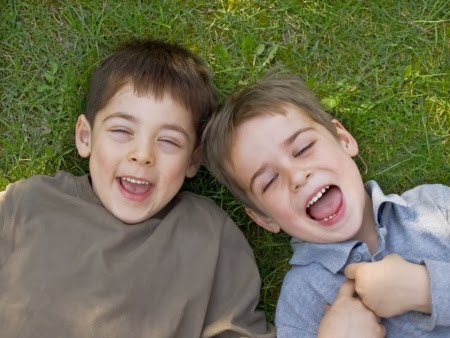 namc montessori encouraging positive behavior two boys laughing on grass