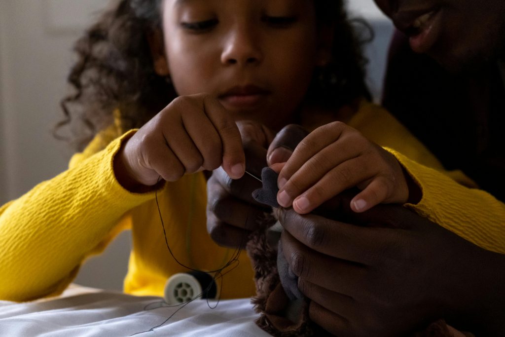 adult and child sewing together