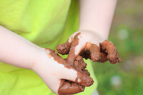 namc montessori sensorial work with soil exploring earth child holding mud