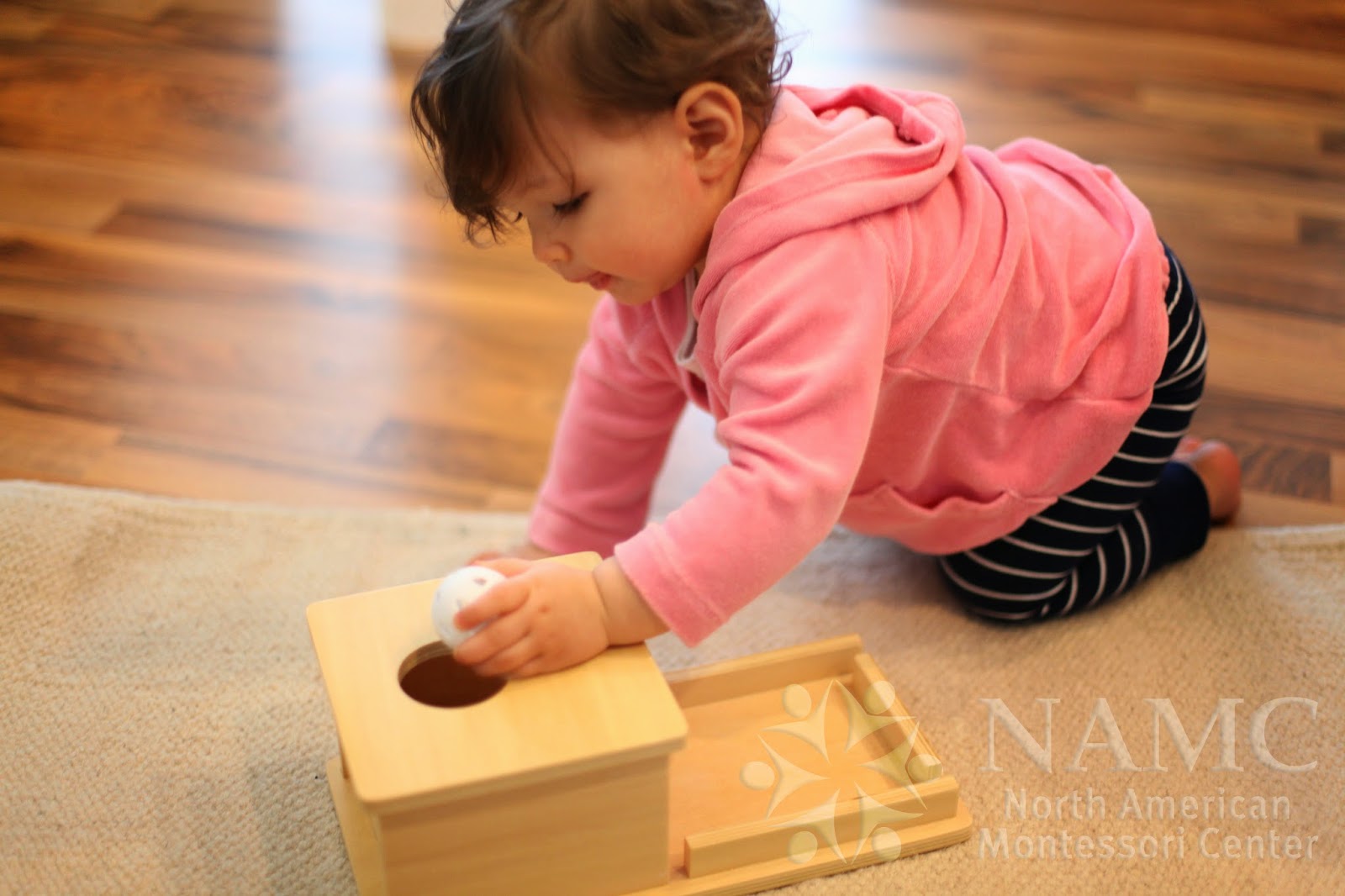 NAMC Montessori developing object permanence girl with box and ball