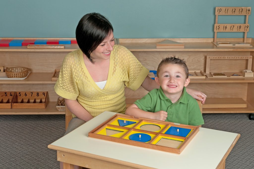 Montessori teacher and child working with the Geometric Demonstration Tray