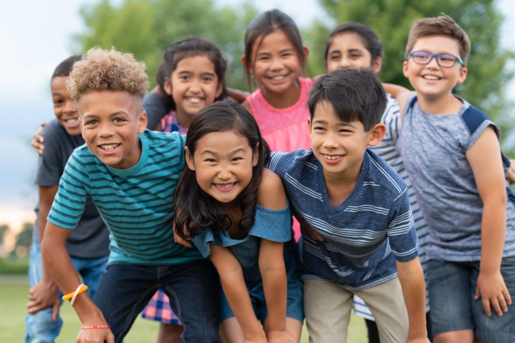 diverse group of elementary age children smiling outside