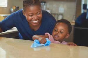 Child and mother cleaning kitchen counter