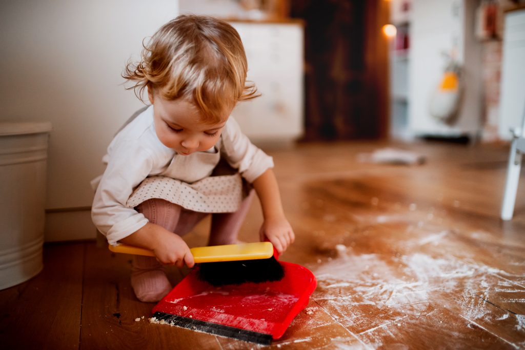 toddler cleaning floor with brush and dustpan