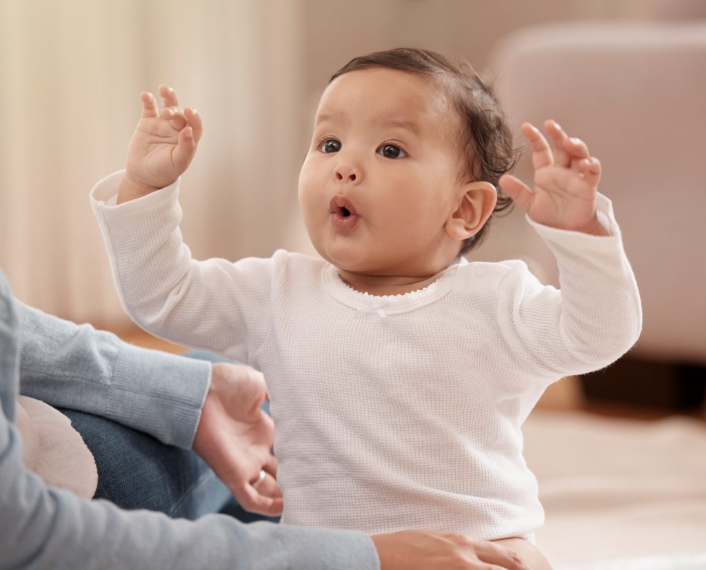 infant raising arms in excitement
