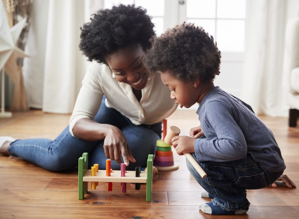 mother and son hammering pegs into toy