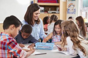 Montessori teacher and group of students working together at table