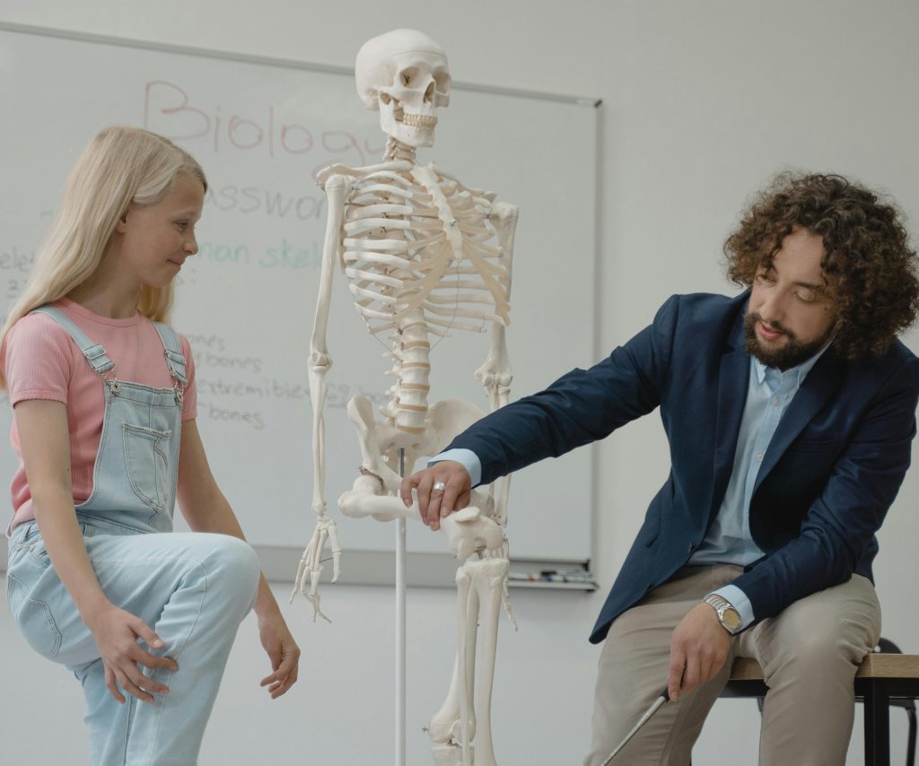 teacher and student looking at skeleton