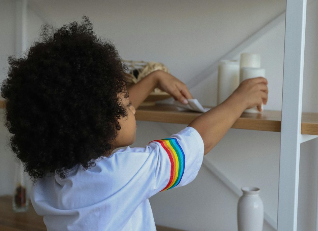 Student cleaning items on classroom shelf