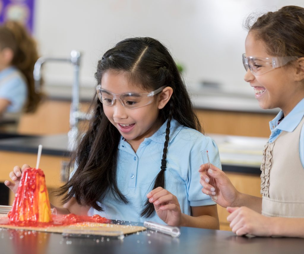 Two elementary students creating a volcano