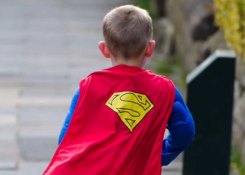 NAMC montessori second plane of development, the age of morals and ethical thinking. Boy running with superman cape.