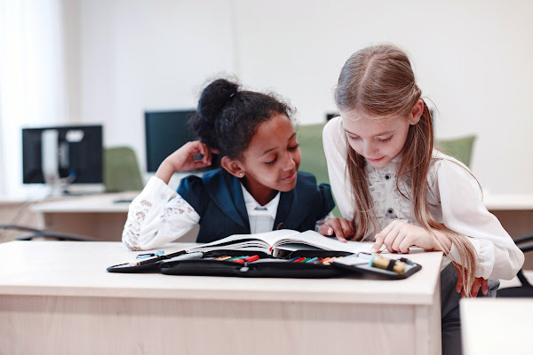 Two Montessori students reading together