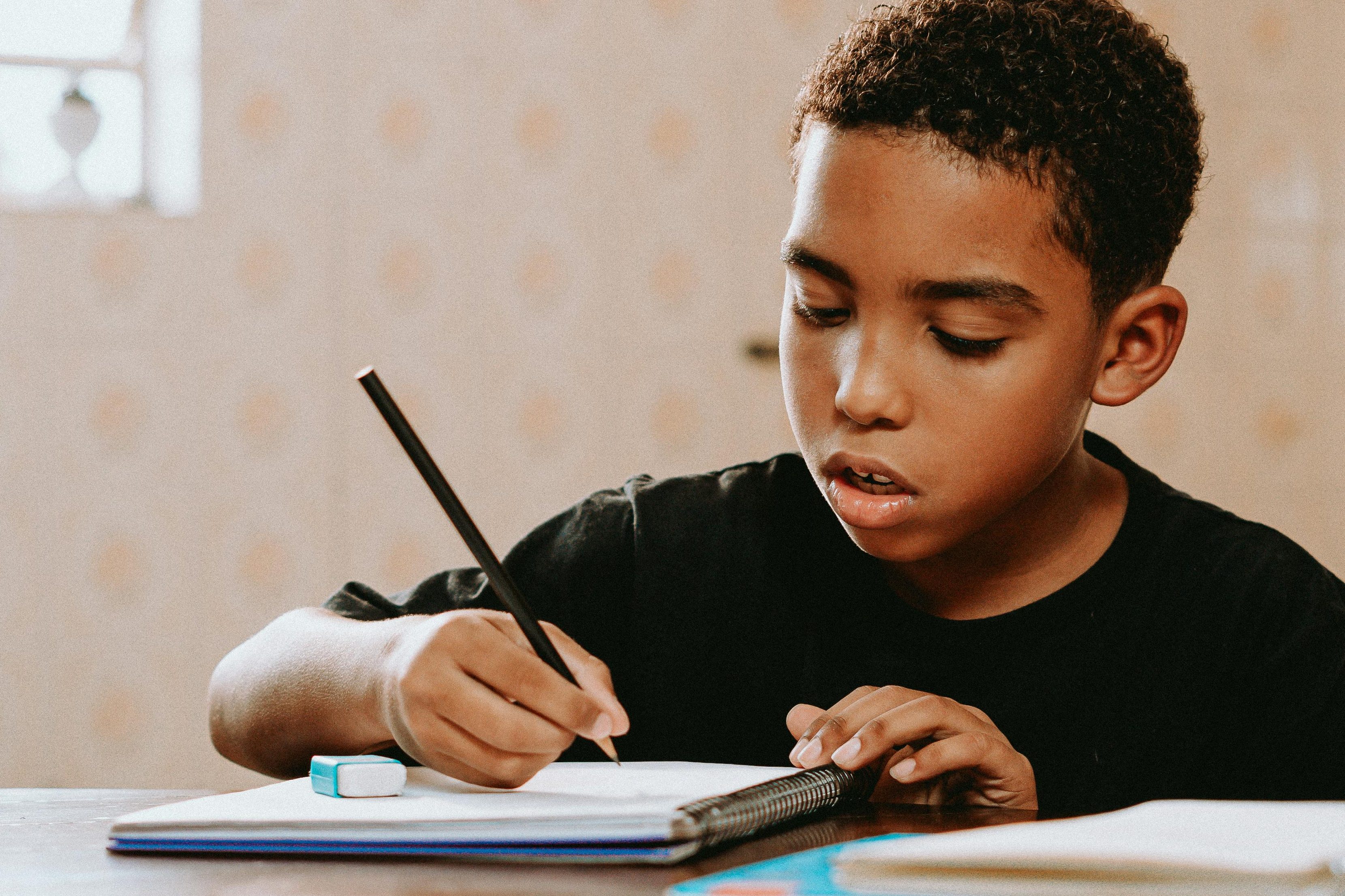 Elementary student writing in his journal